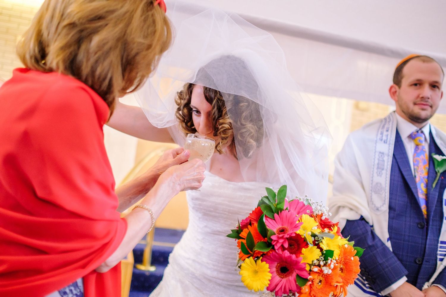 Colorful bouquet of gerbera daisies and flowers being held during wedding celebration.