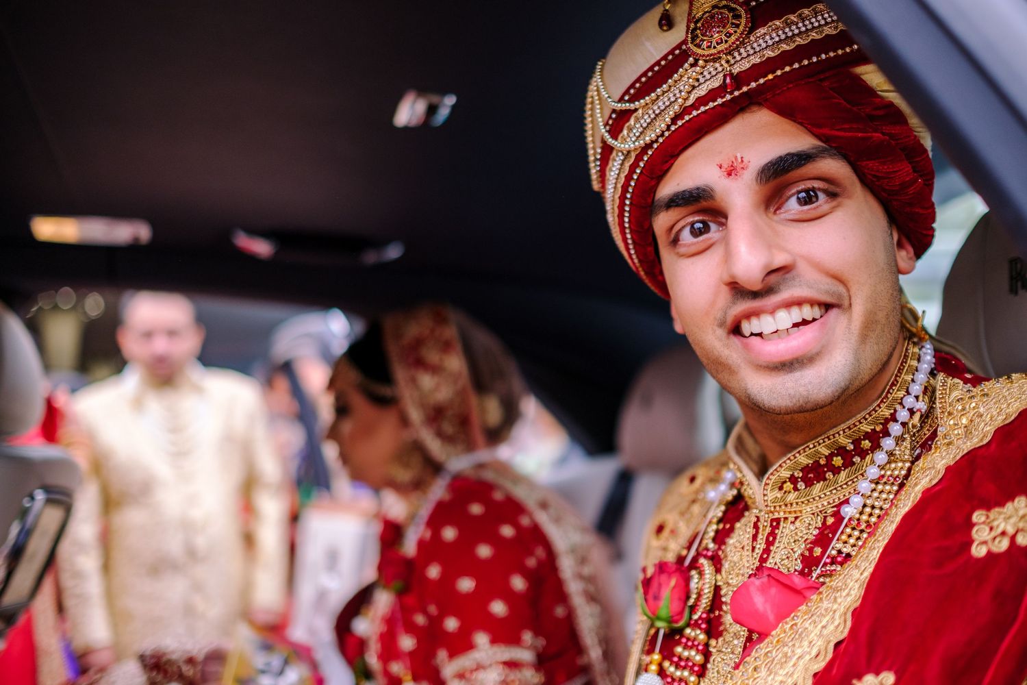 Wedding celebration with traditional Indian attire and decorative elements indoors.
