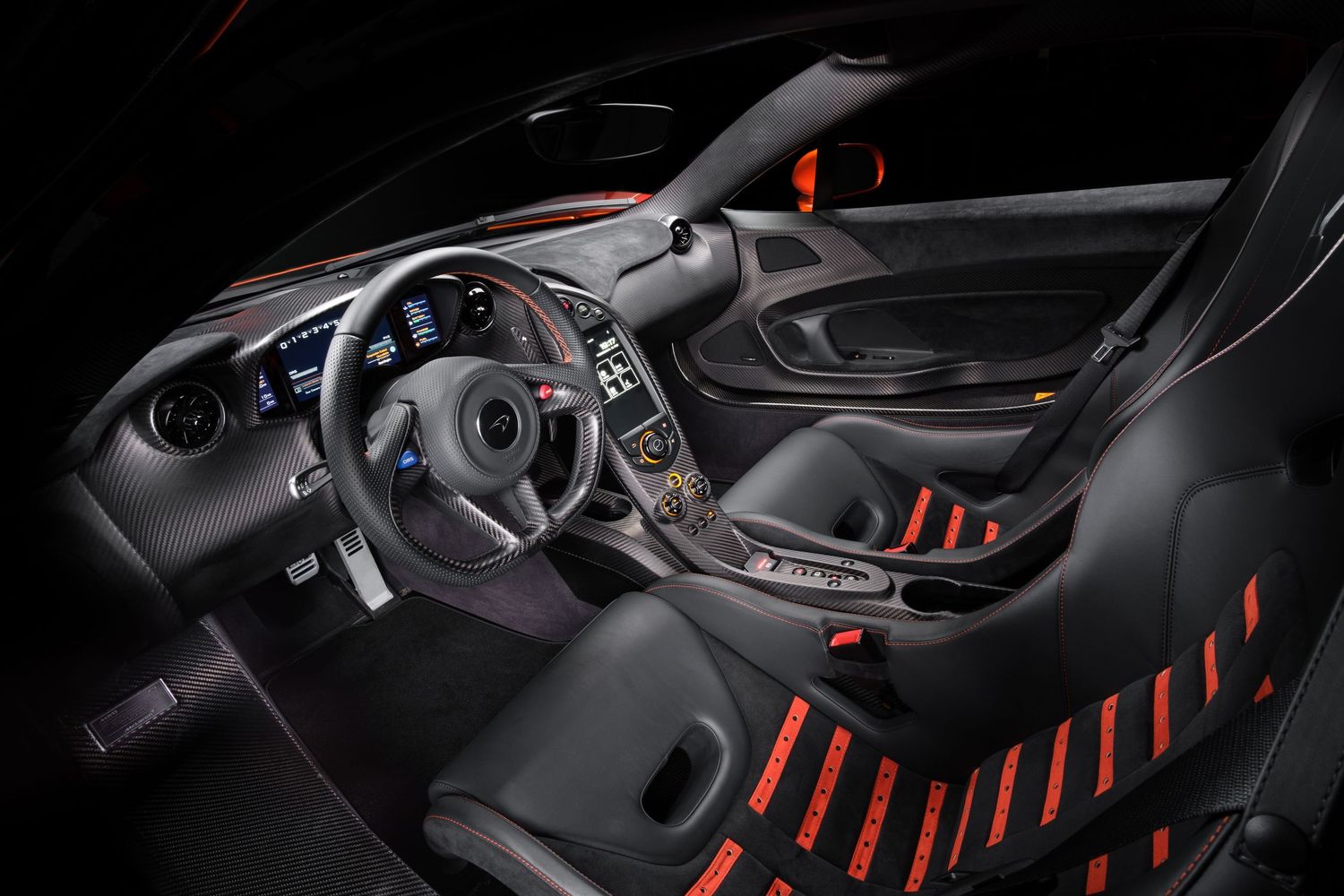 Interior view of luxury sports car dashboard with red accents and carbon fiber details.