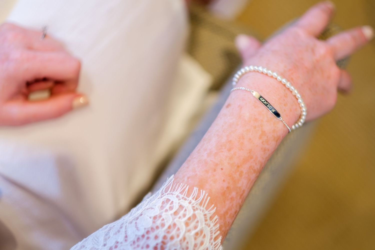 Glittery pink nail polish being applied to fingernails in a manicure process.