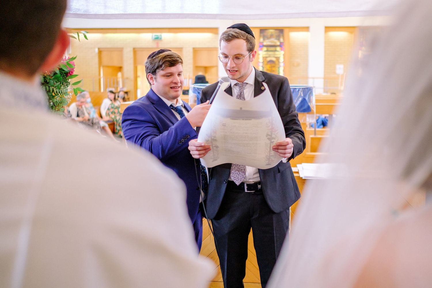 Indoor wedding ceremony with guests seated in rows watching proceedings.