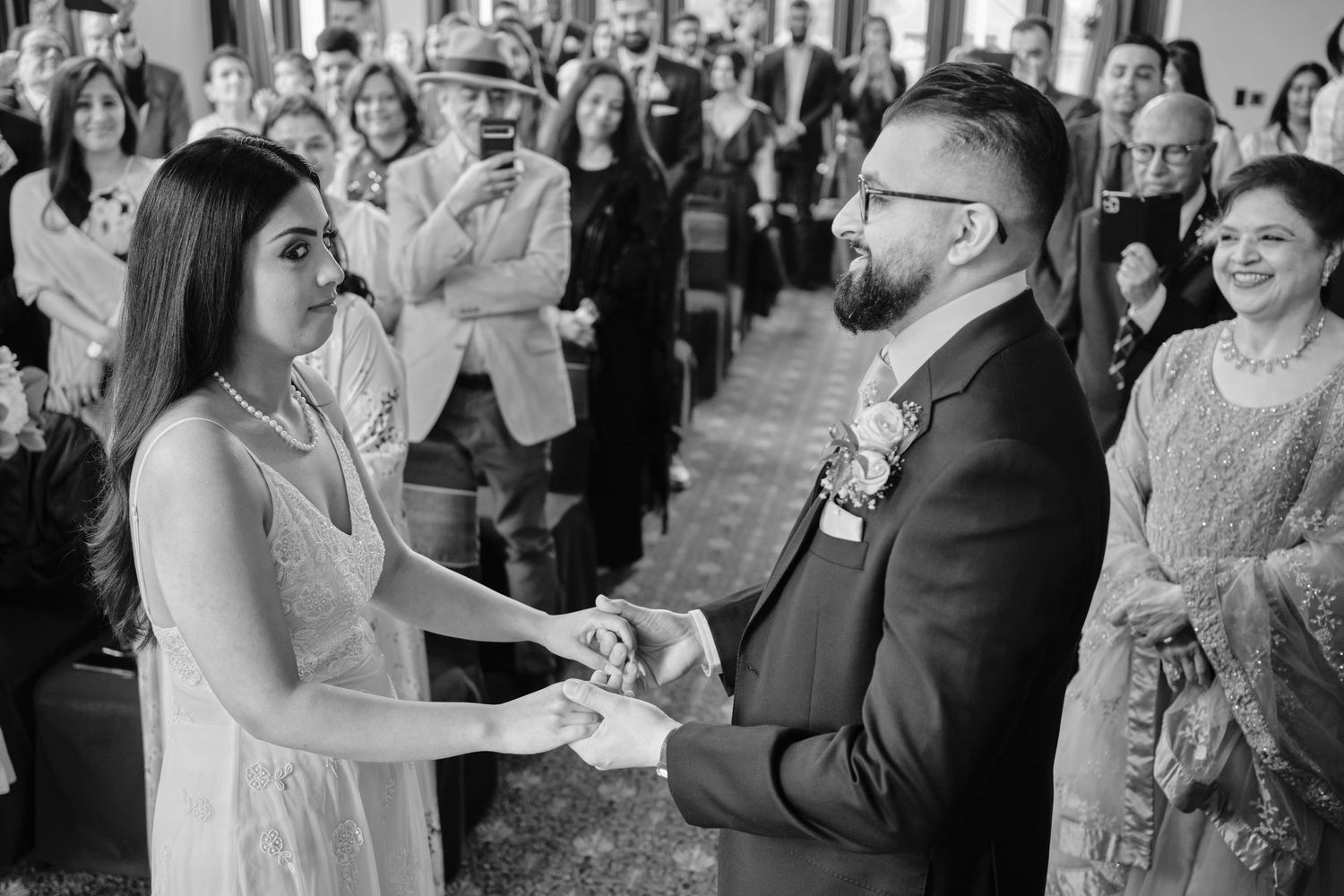 Black and white photo of wedding guests reacting during ceremony.