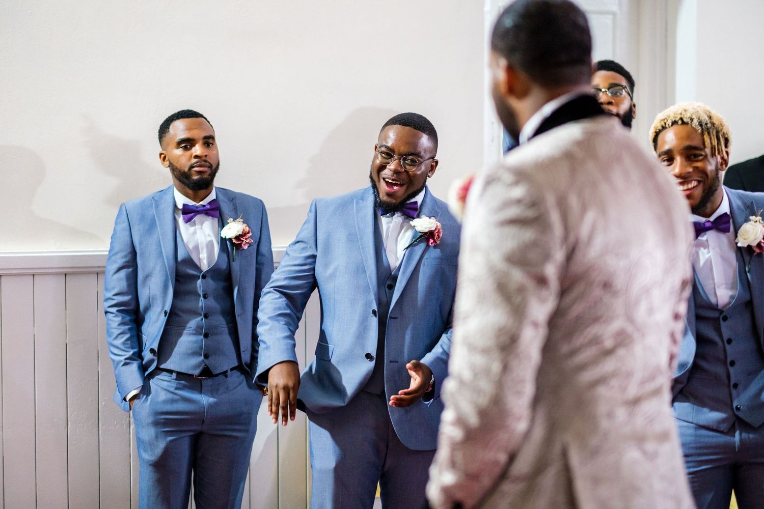 Groomsmen in light blue suits pose together at a formal wedding celebration.