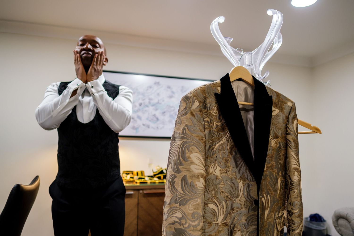 Military dress uniforms hang on display before a formal event.