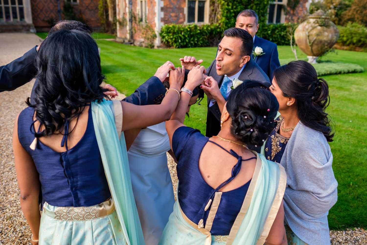 A group of people gather outdoors at a garden party, engaged in conversation and celebration.