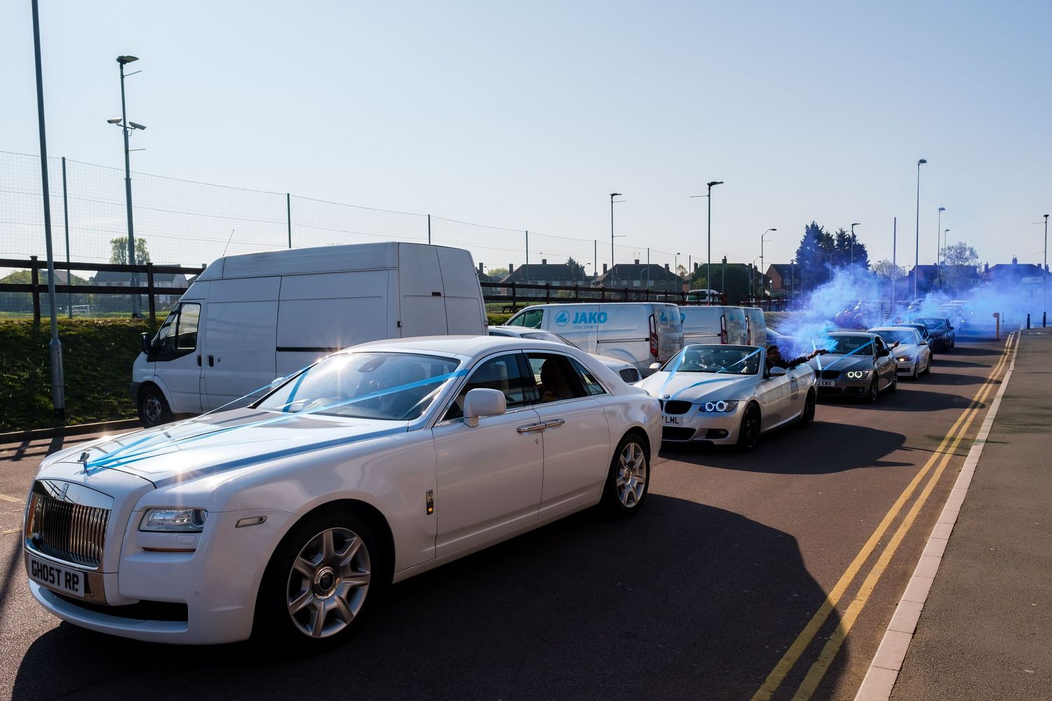 A row of luxury Rolls-Royce vehicles parked in a line at an outdoor dealership or event space.