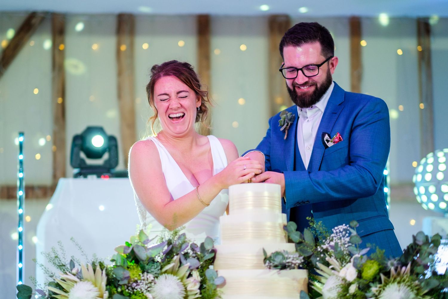 Reception celebration with twinkle lights and floral table decorations.