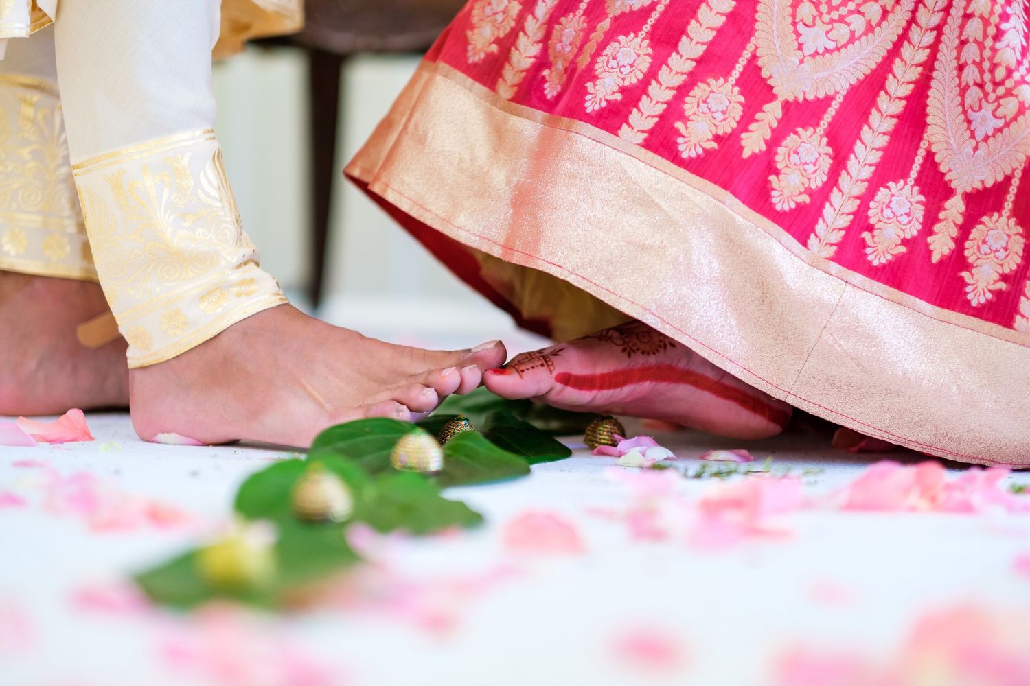 Close-up detail of pink and gold embroidered wedding fabric with delicate patterns.