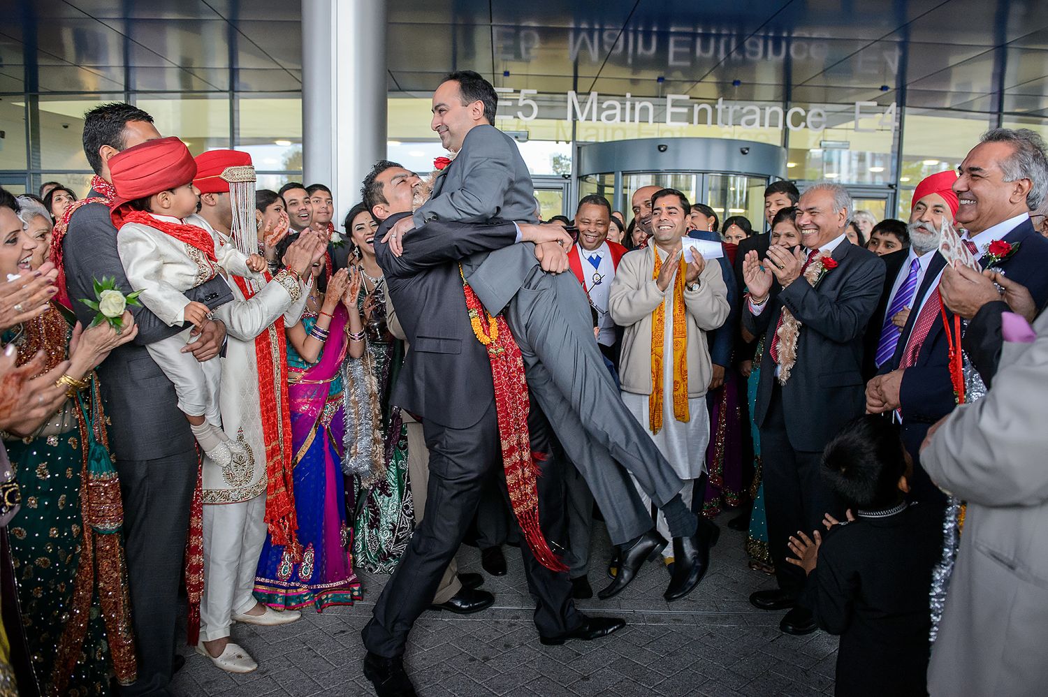 Wedding reception dance floor filled with guests celebrating in colorful traditional attire.
