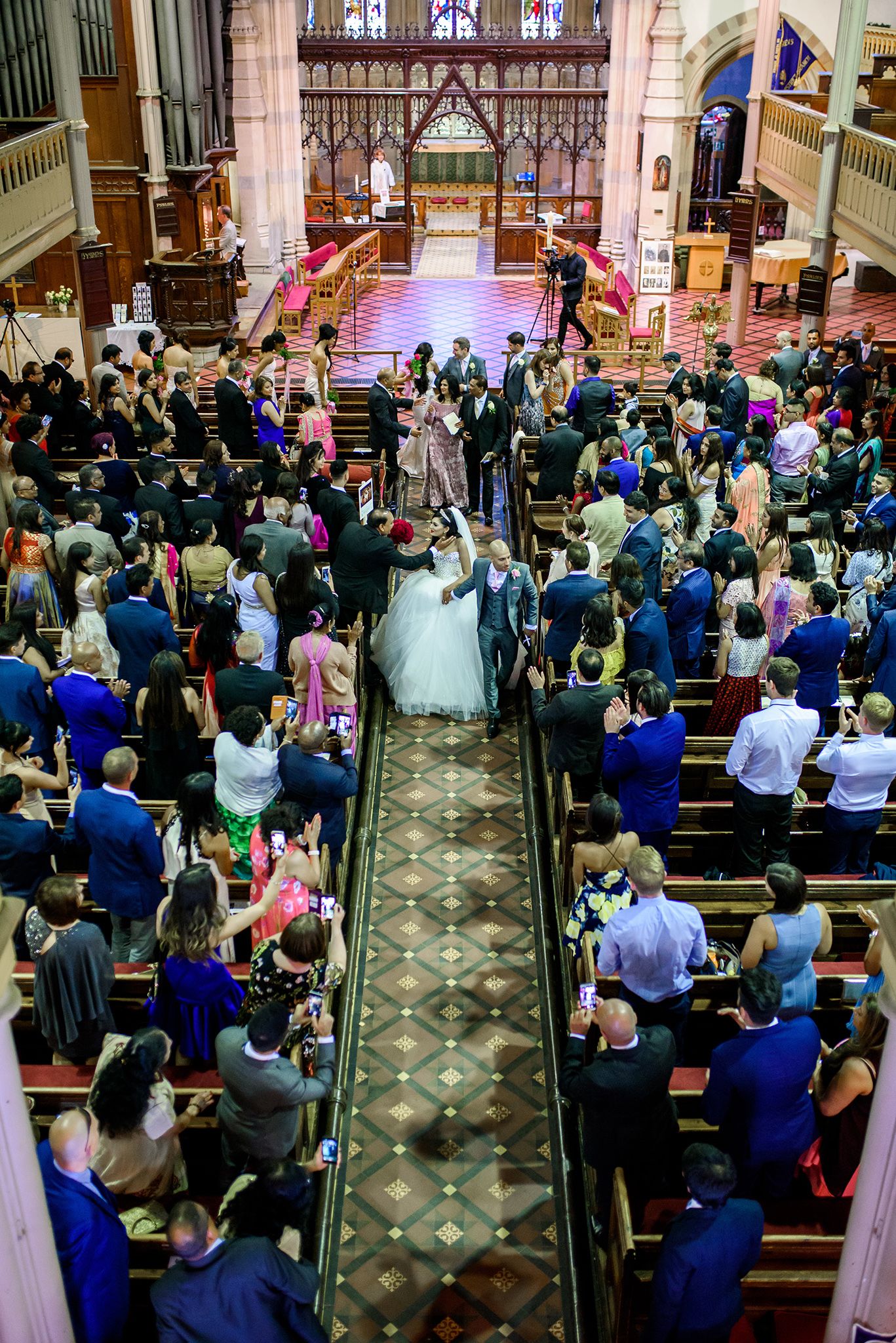 Elevated view of packed church wedding ceremony with guests filling the pews.