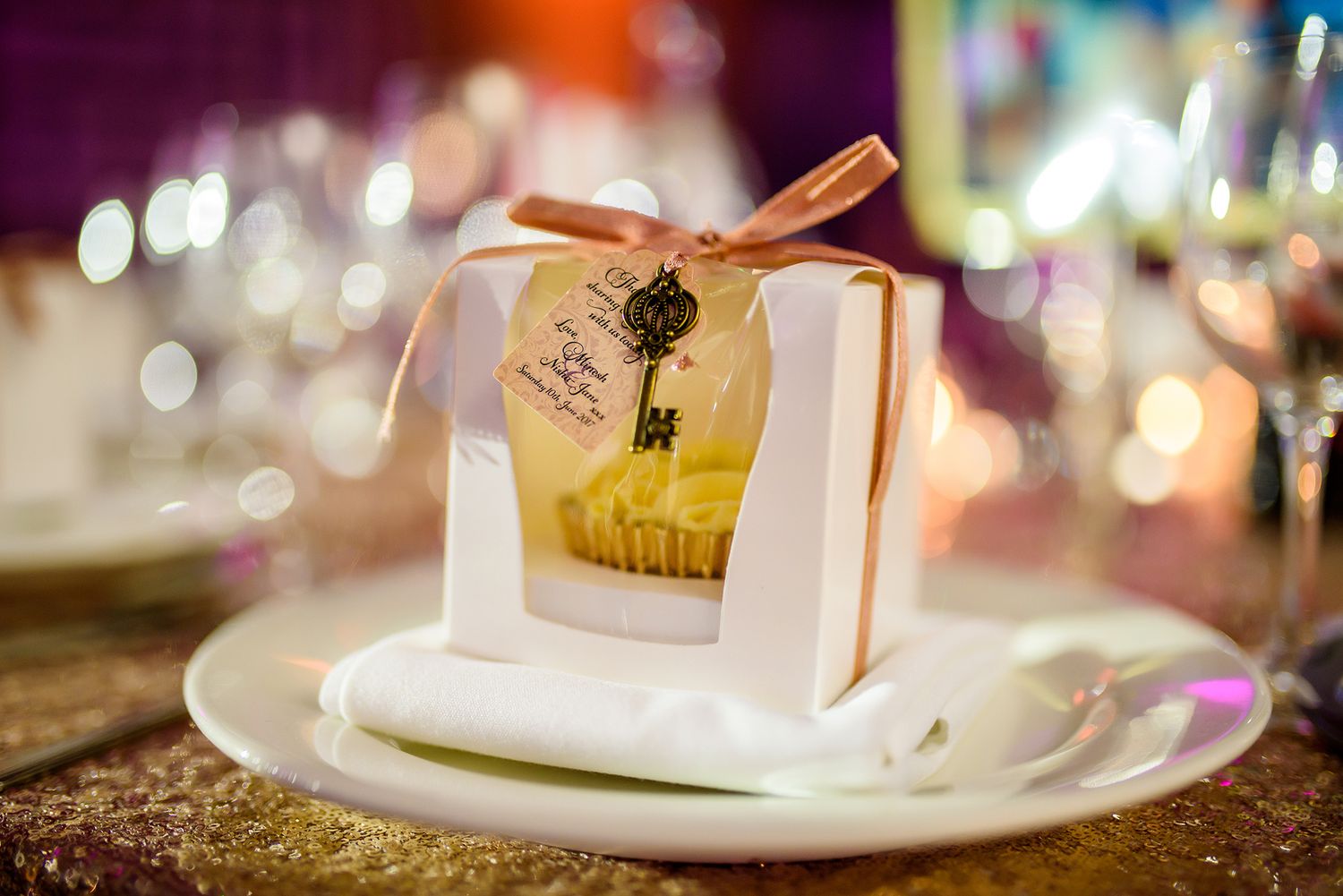 Elegant wedding reception table settings with soft candlelight and favors.