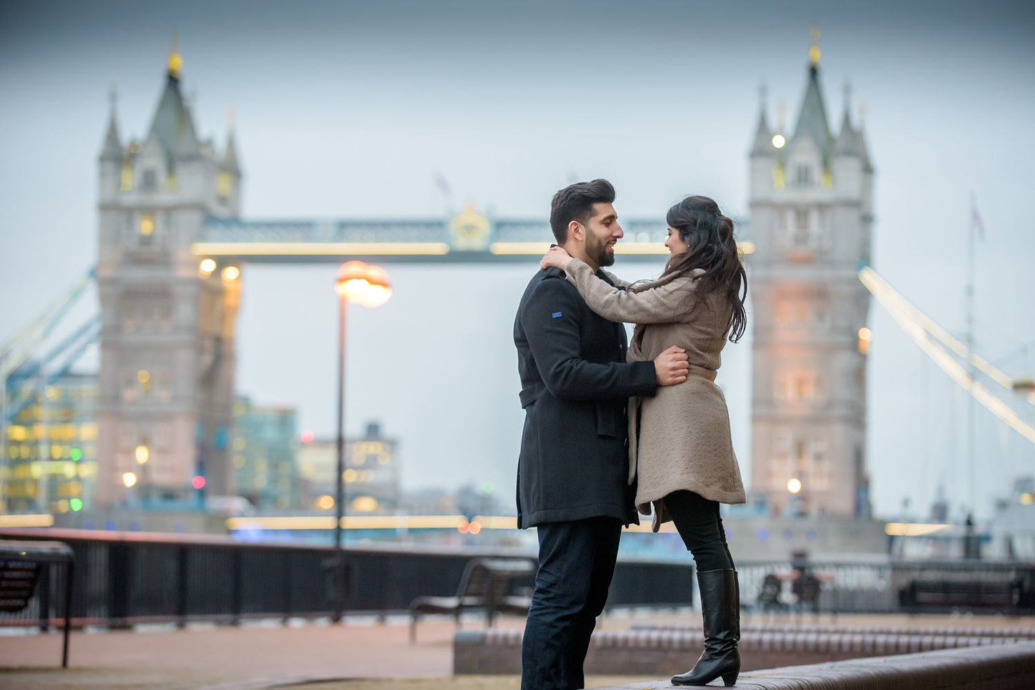 Romantic photoshoot on Tower Bridge with London cityscape at dusk.
