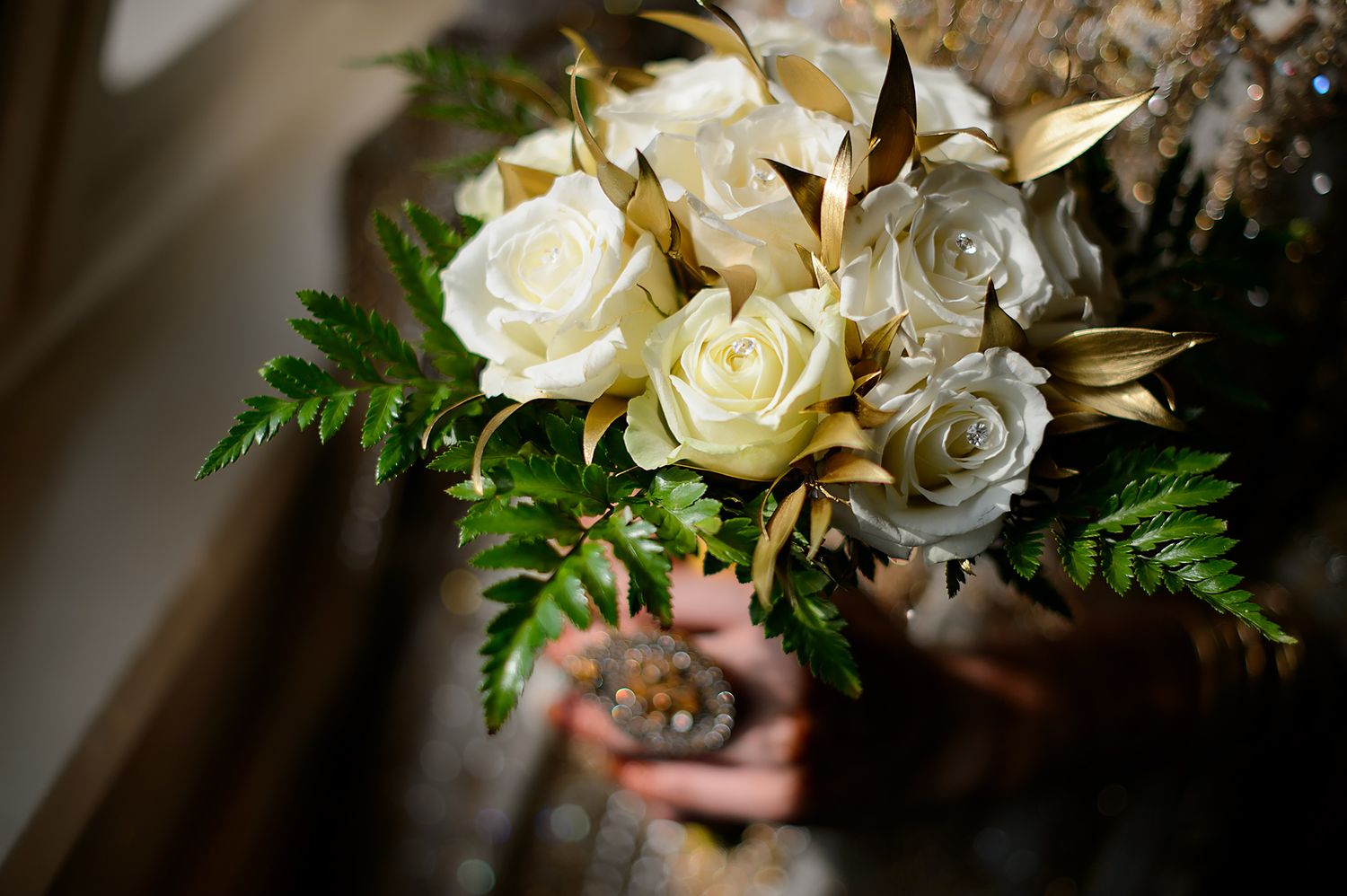 Elegant white rose and fern wedding bouquet with classic styling.