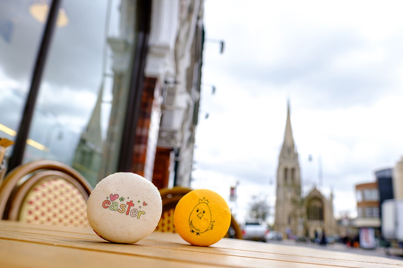 Still life arrangement of white and yellow decorative eggs with a church spire visible through a window.