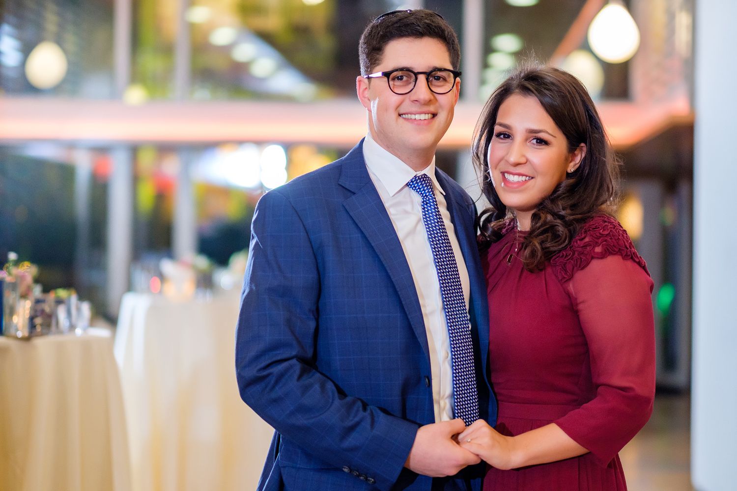 Couple in formal attire sharing a romantic moment in an outdoor urban setting.