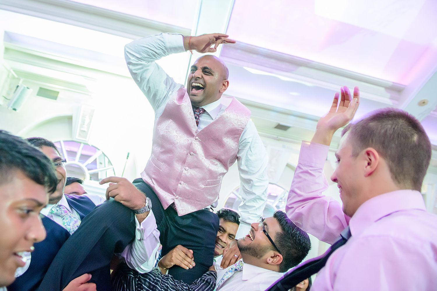 Party guests lift and celebrate during an energetic reception dance.