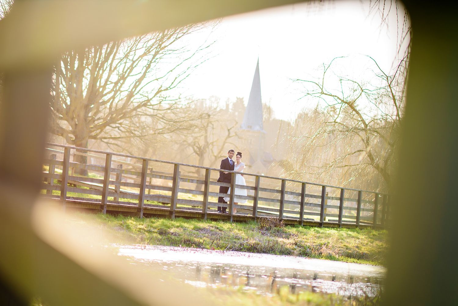 Scenic countryside landscape with wooden fencing and trees in soft sunlight.