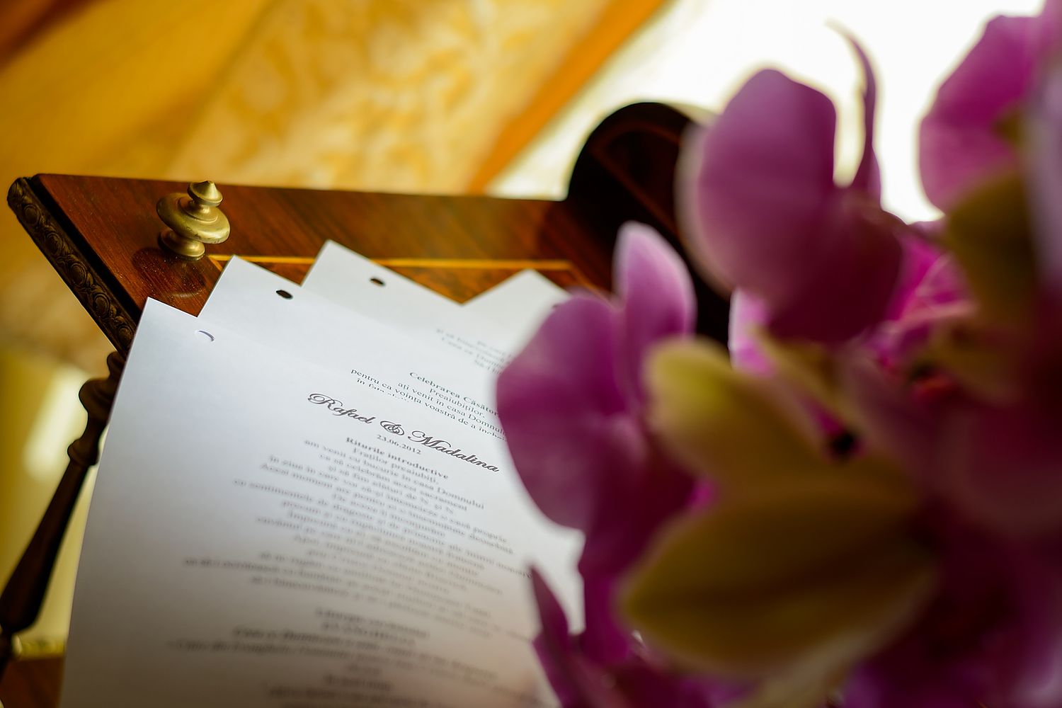 Wedding ceremony documents with purple orchids in soft focus.