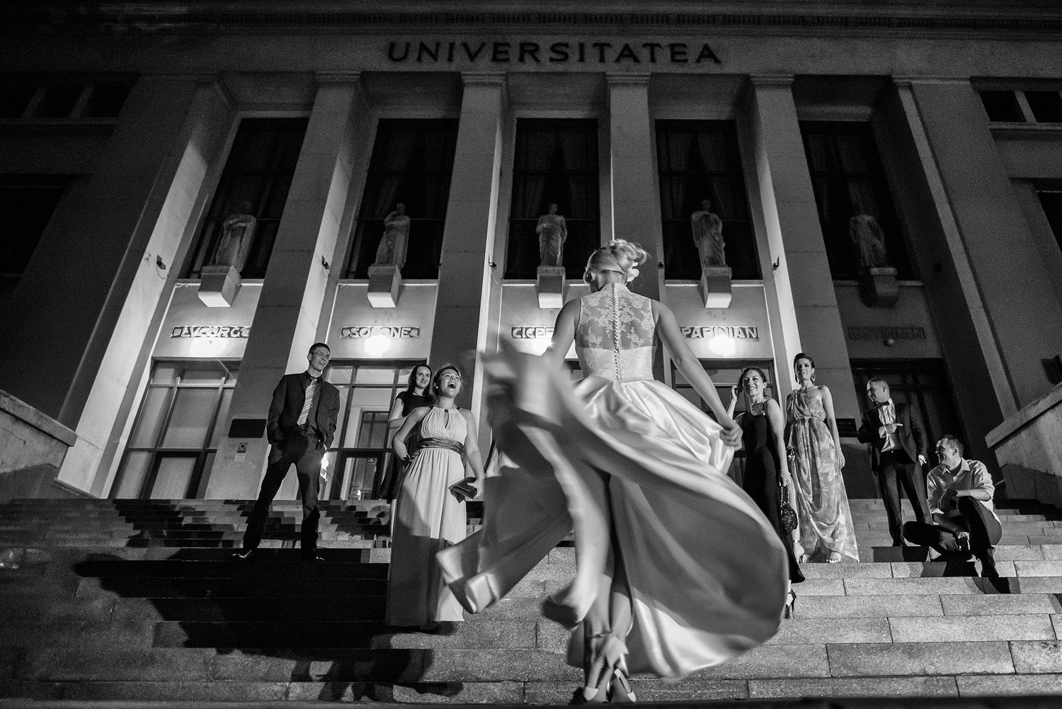 Grand university building exterior facade with classical columns at night.