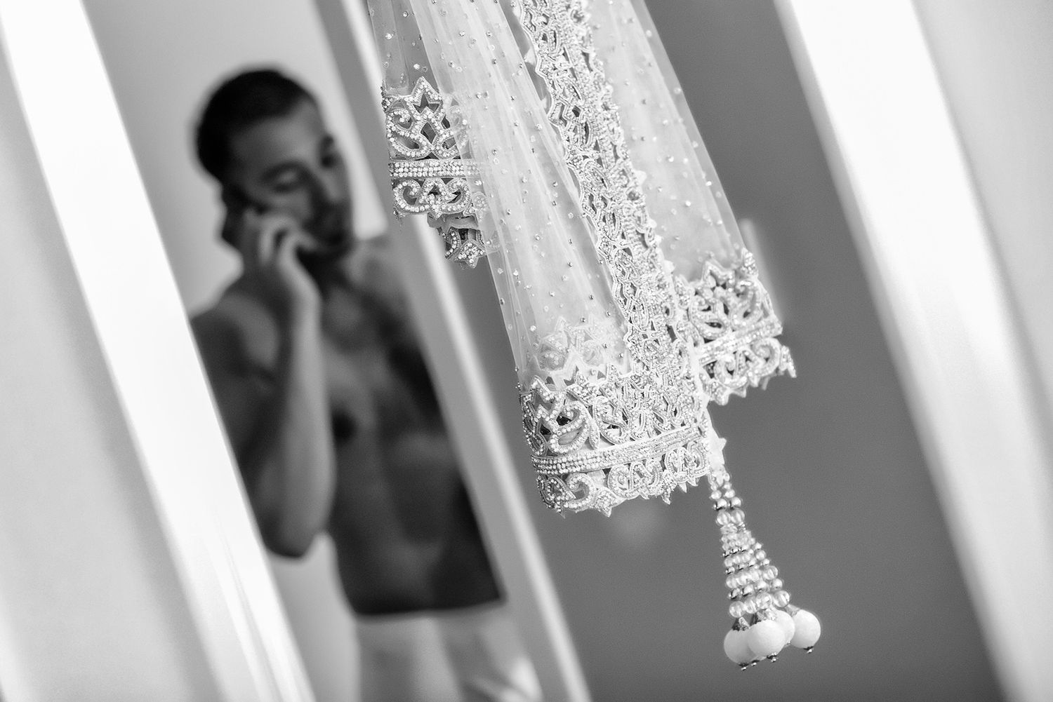 Decorative white lace curtains photographed in soft focus with light streaming through.