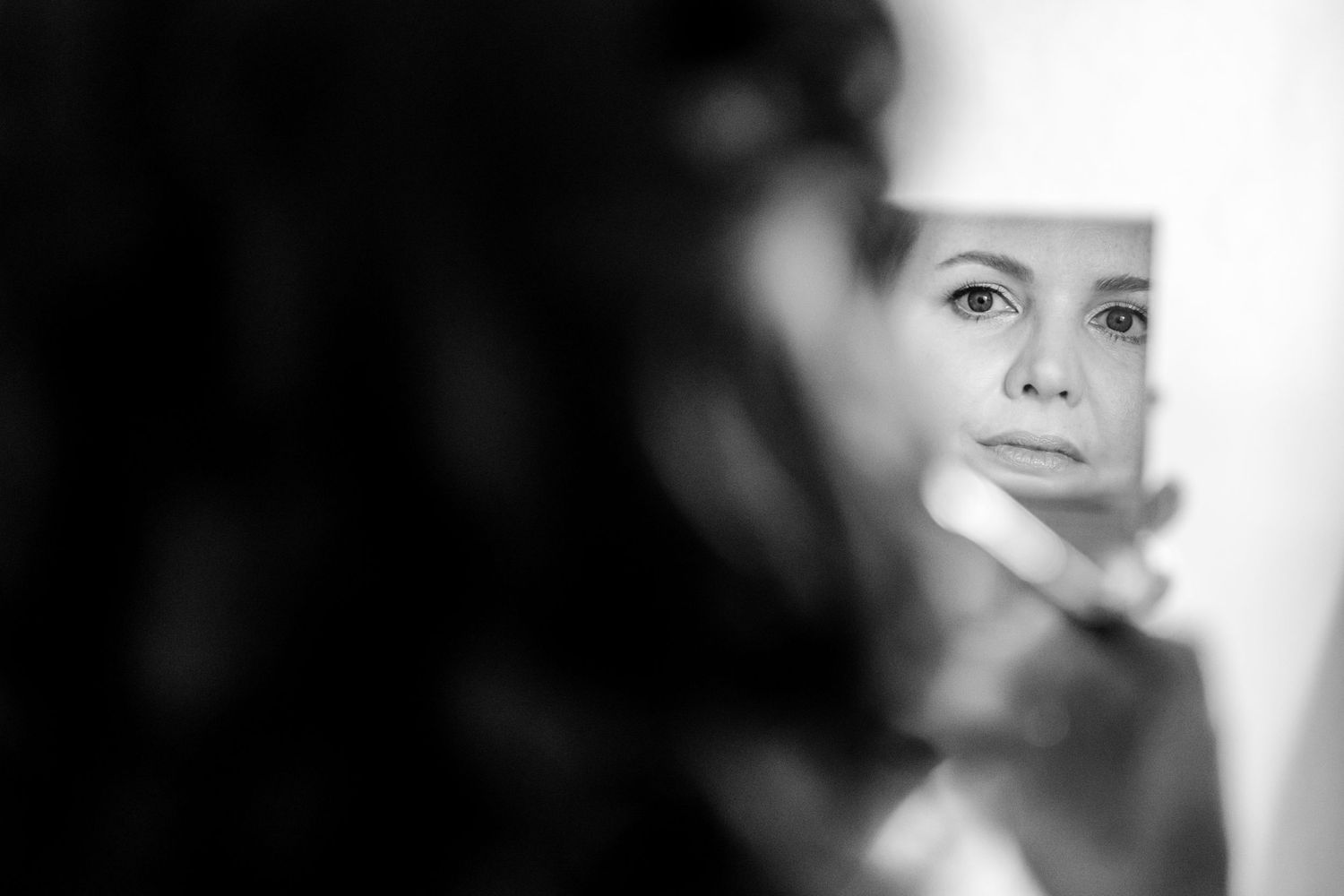 Professional portrait photograph in black and white with dramatic lighting and shallow depth of field.
