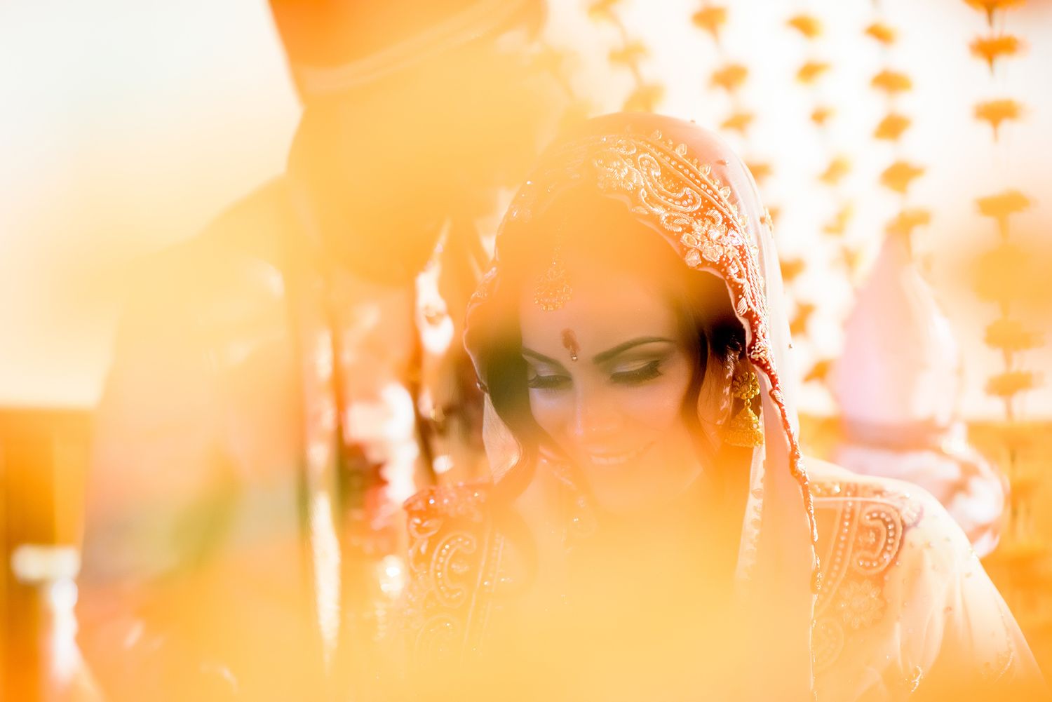 Traditional Indian wedding ceremony taking place under warm glowing lights and decorations.