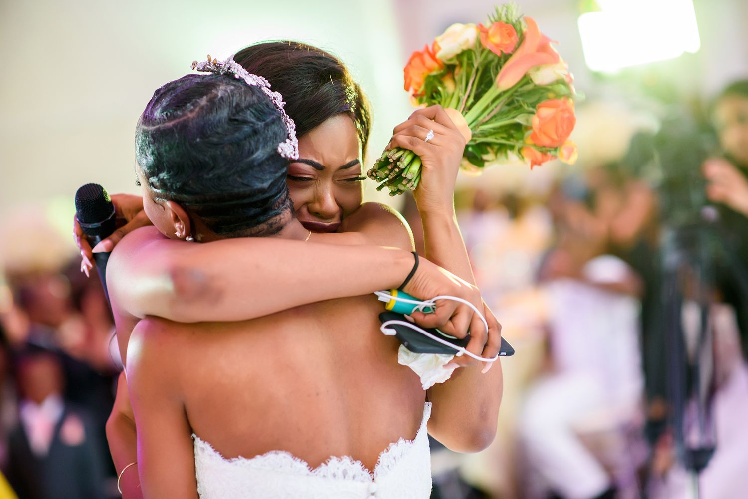 Wedding celebration with guests toasting and celebrating in a bright reception venue.