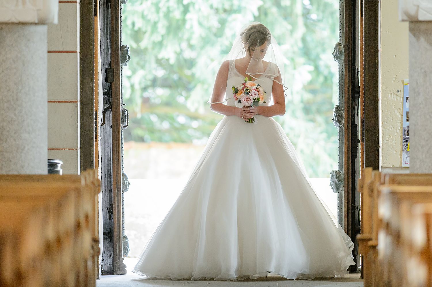 Sunlit bridal portraits showcasing a flowing white ballgown against classic architecture.