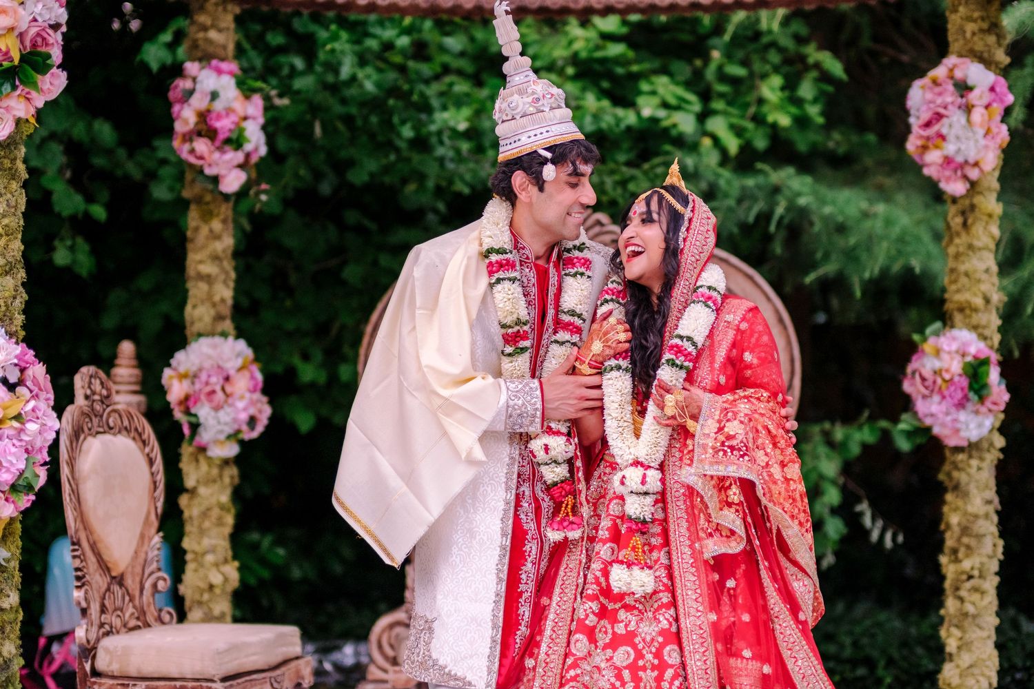 Garden wedding ceremony setup with pink floral decorations and traditional elements.
