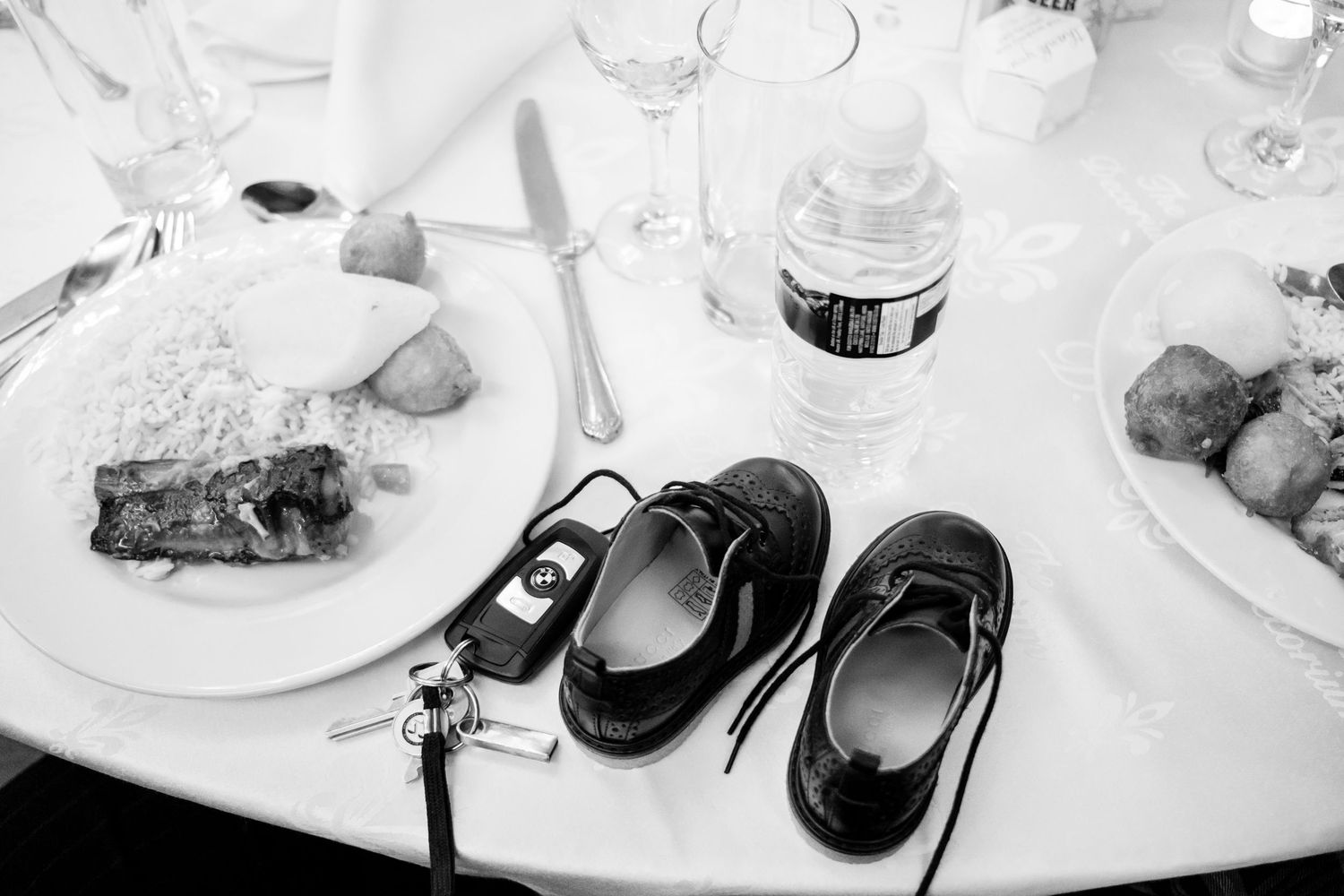 Place settings at a wedding reception with wine glasses and plates.