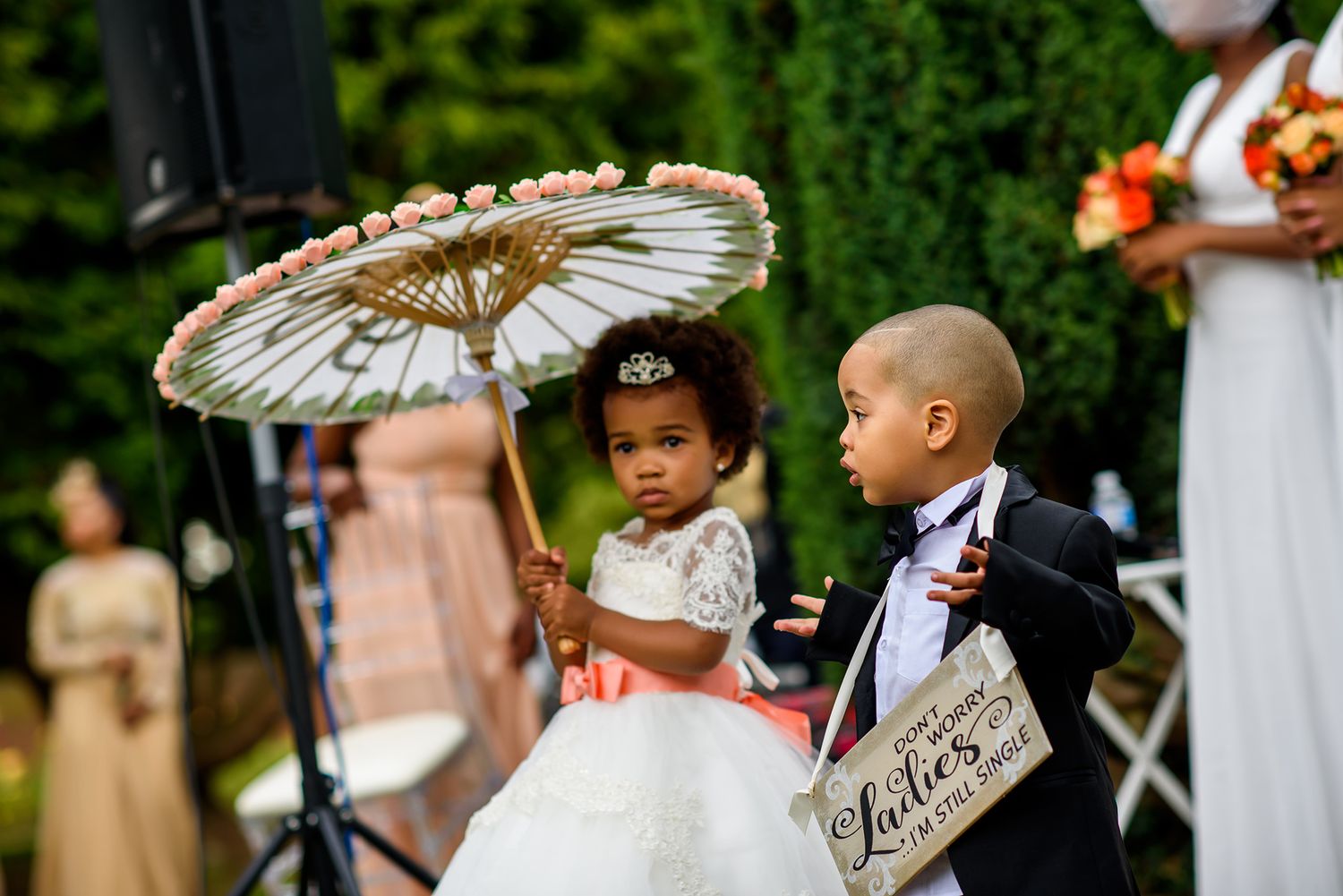 Wedding ceremony featuring decorative white parasols in an outdoor garden setting.