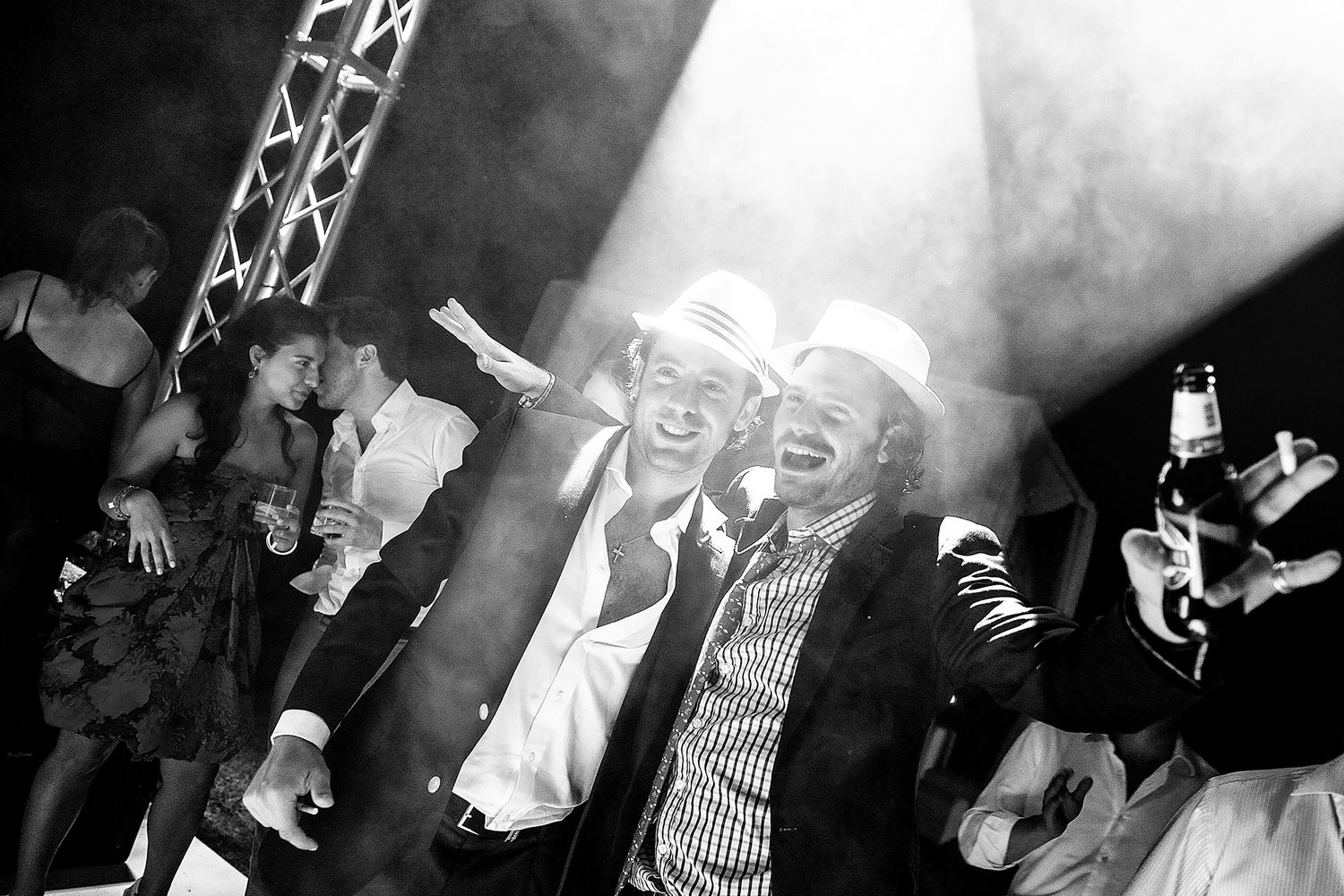 Energetic party scene captured in dramatic black and white with stage lighting effects.