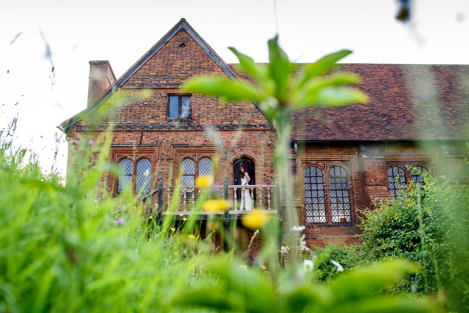 Scenic landscape view of brick buildings through green foliage.