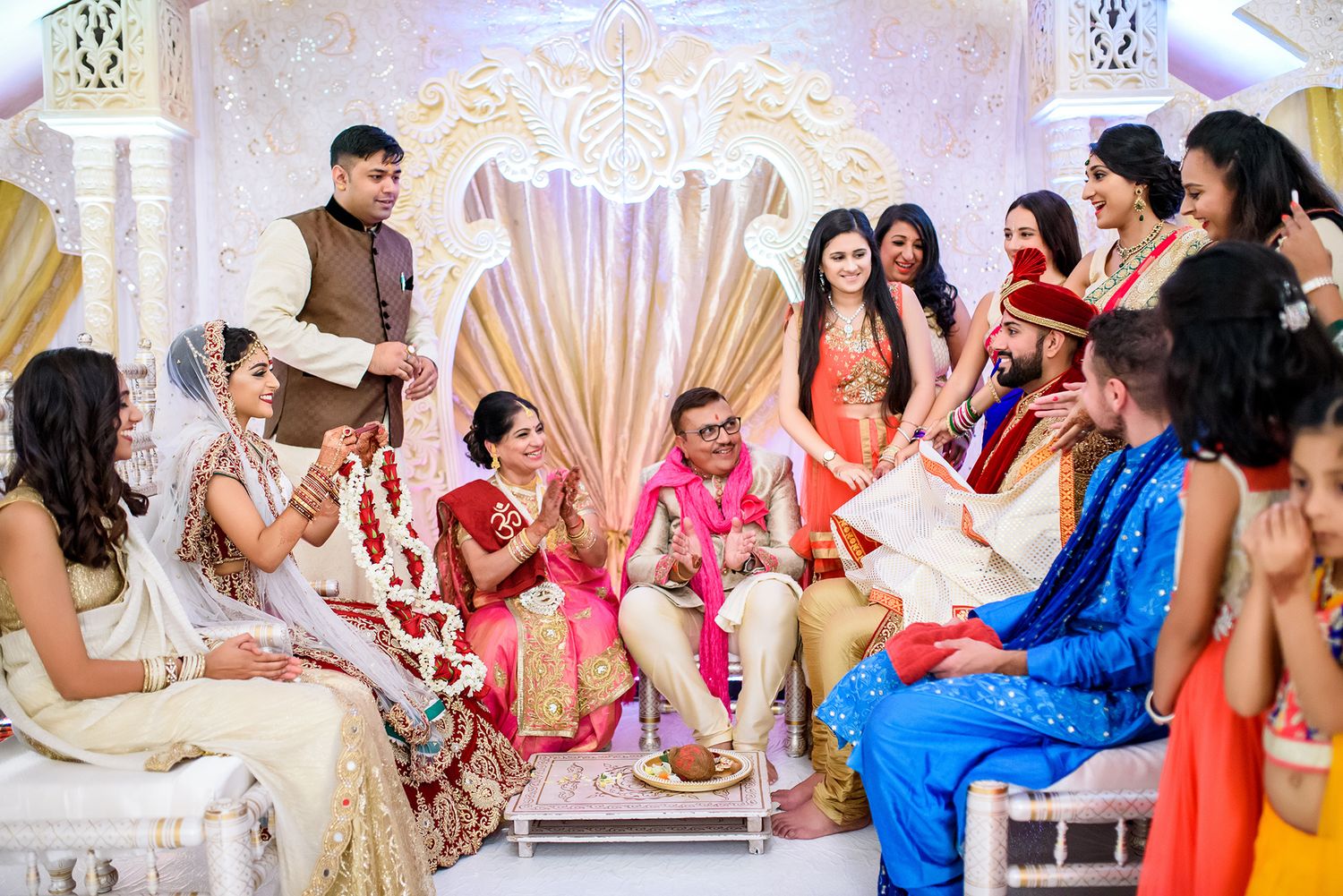 Decorative mandap setup at an elegant Indian wedding with ornate gold and white backdrop.