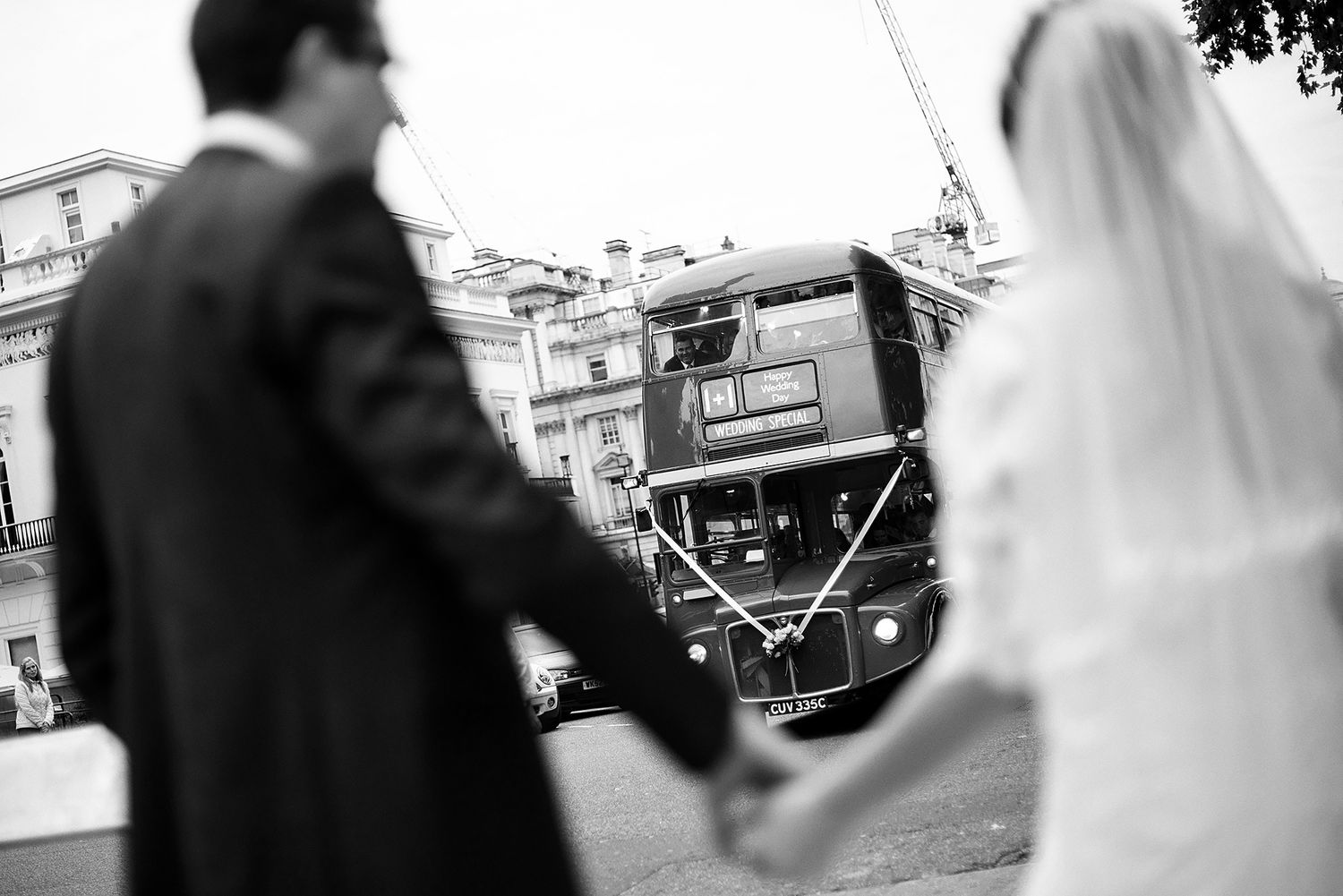 Black and white wedding photo capturing couple walking through city streets.