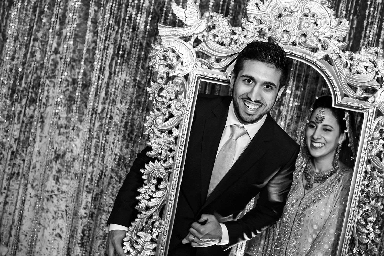 Black and white formal portraits captured against an elegant patterned backdrop.