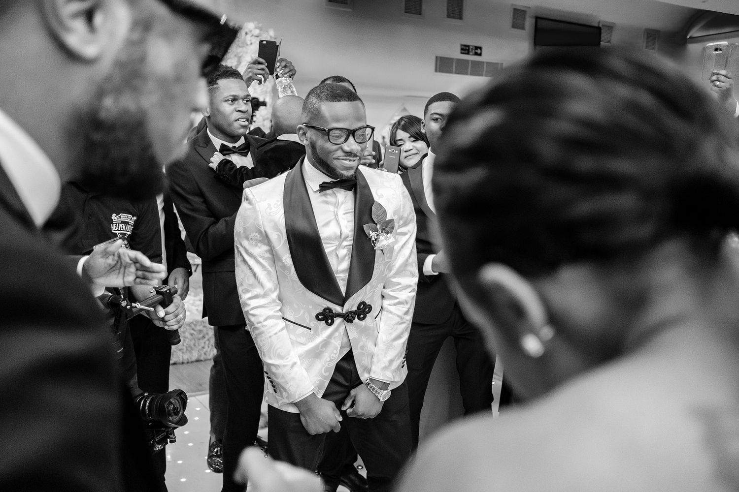 A black and white photo capturing an emotional moment during a wedding reception.