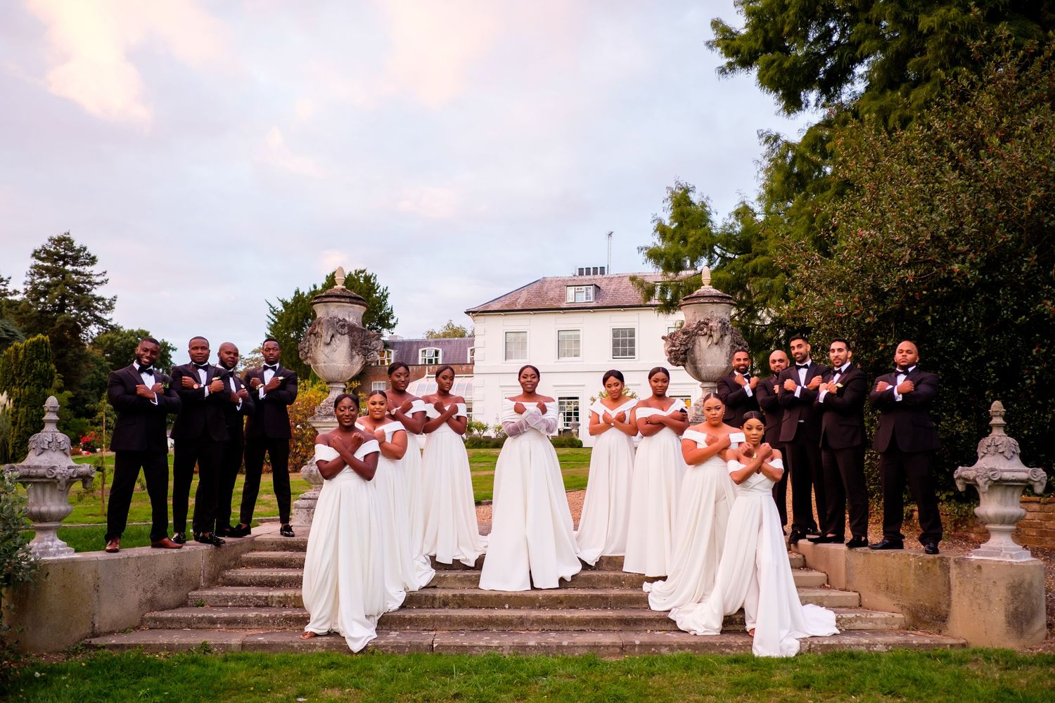 Wedding party members arranged on stone steps for formal outdoor portraits.
