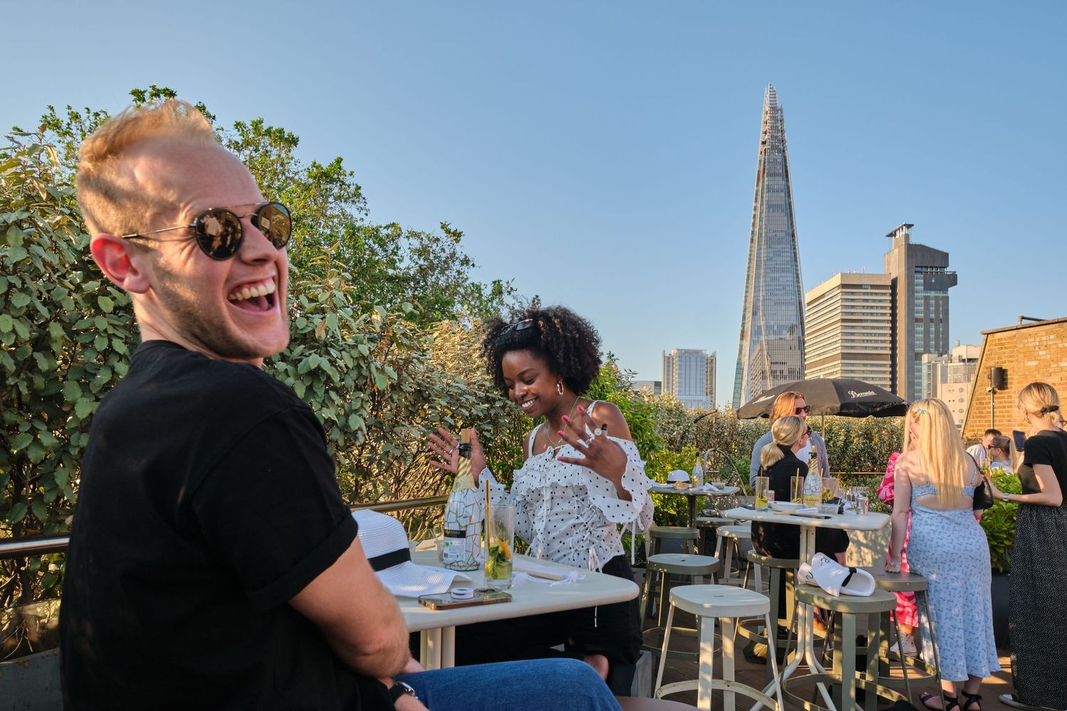 Outdoor rooftop gathering with London's Shard building visible in the background.