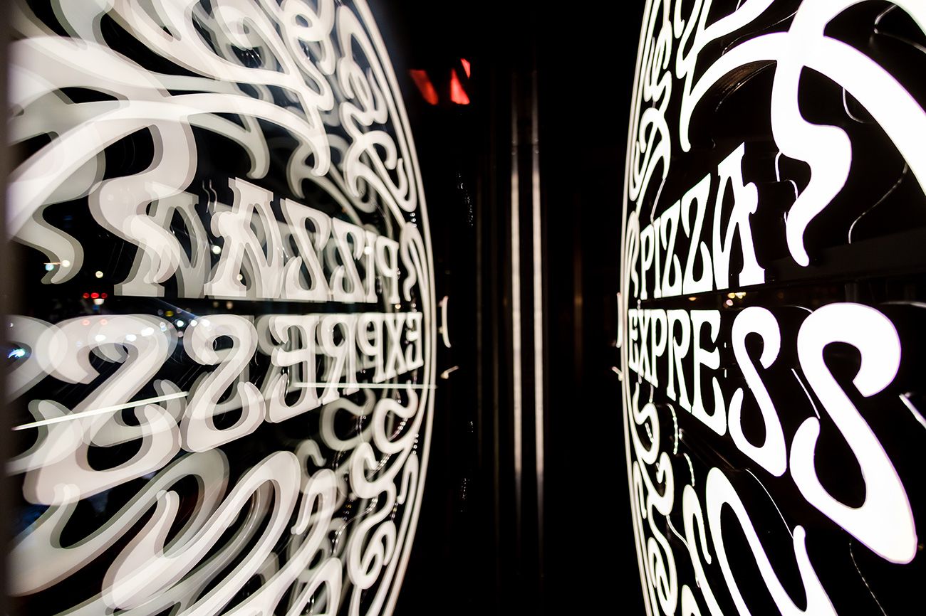 Abstract circular white graffiti pattern against dark background creating tunnel effect.