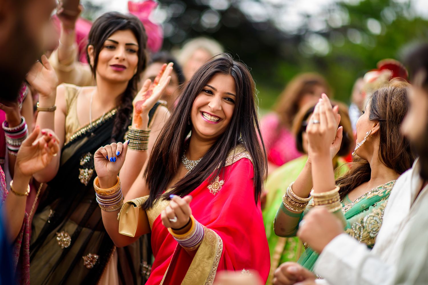 Wedding guests dancing and celebrating during outdoor festivities.