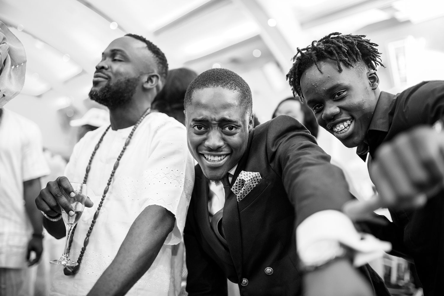 Black and white photo series capturing candid laughter and joy during wedding celebrations.