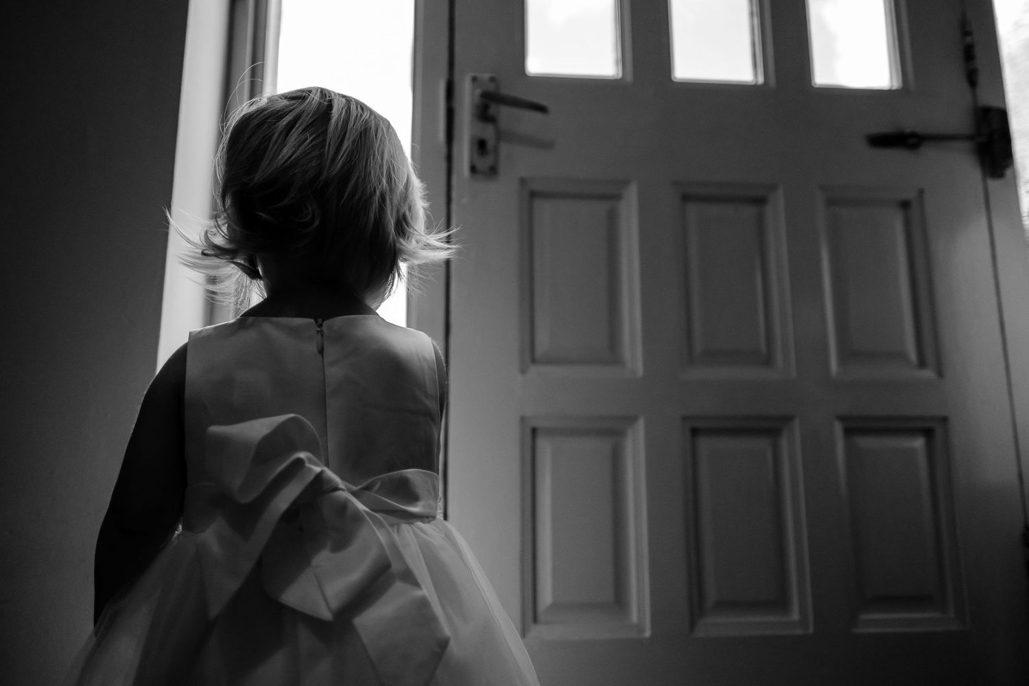 Dramatic black and white silhouettes of wedding preparation through doorways and windows.