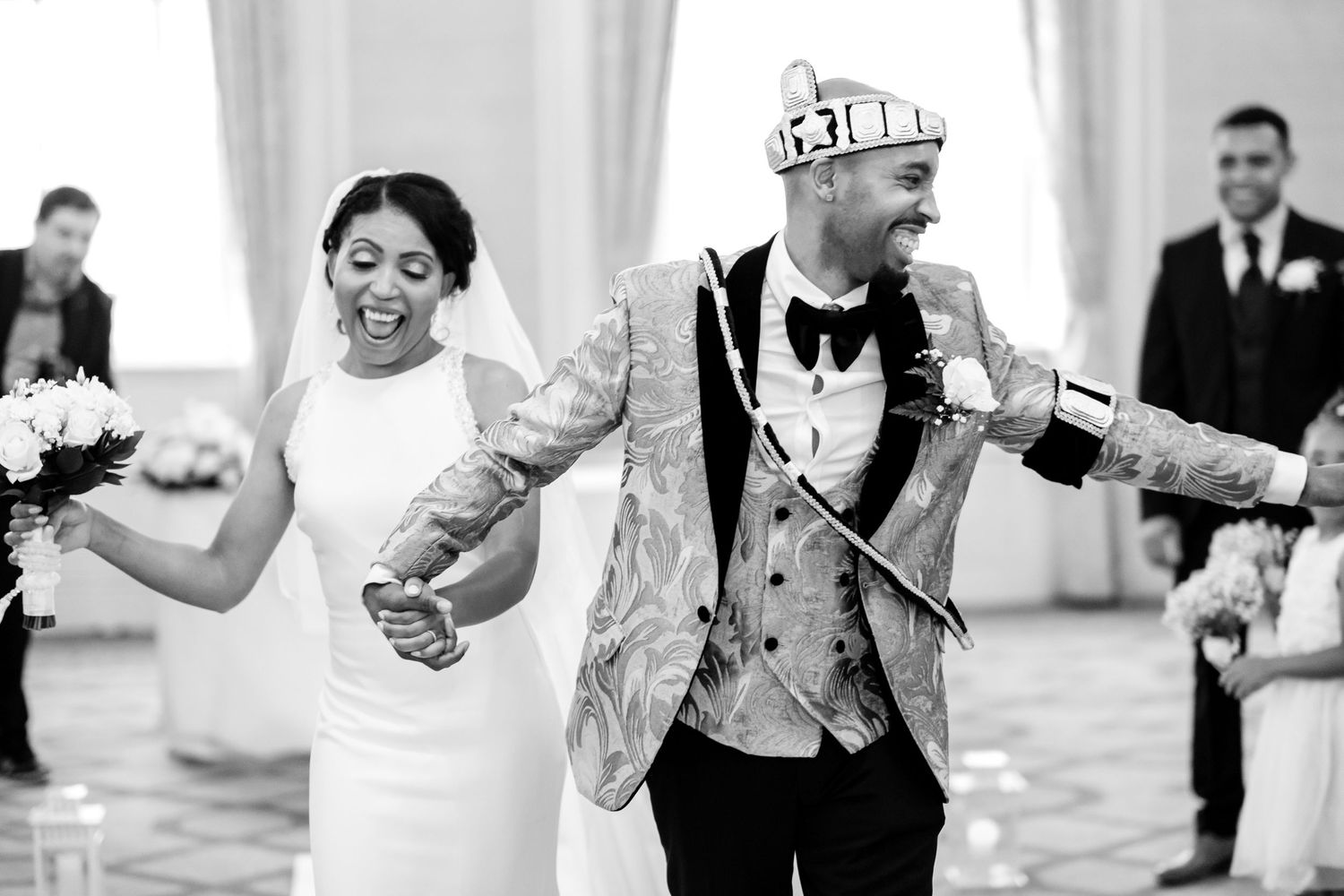 Wedding guests raise their glasses in a celebratory toast at an elegant reception.