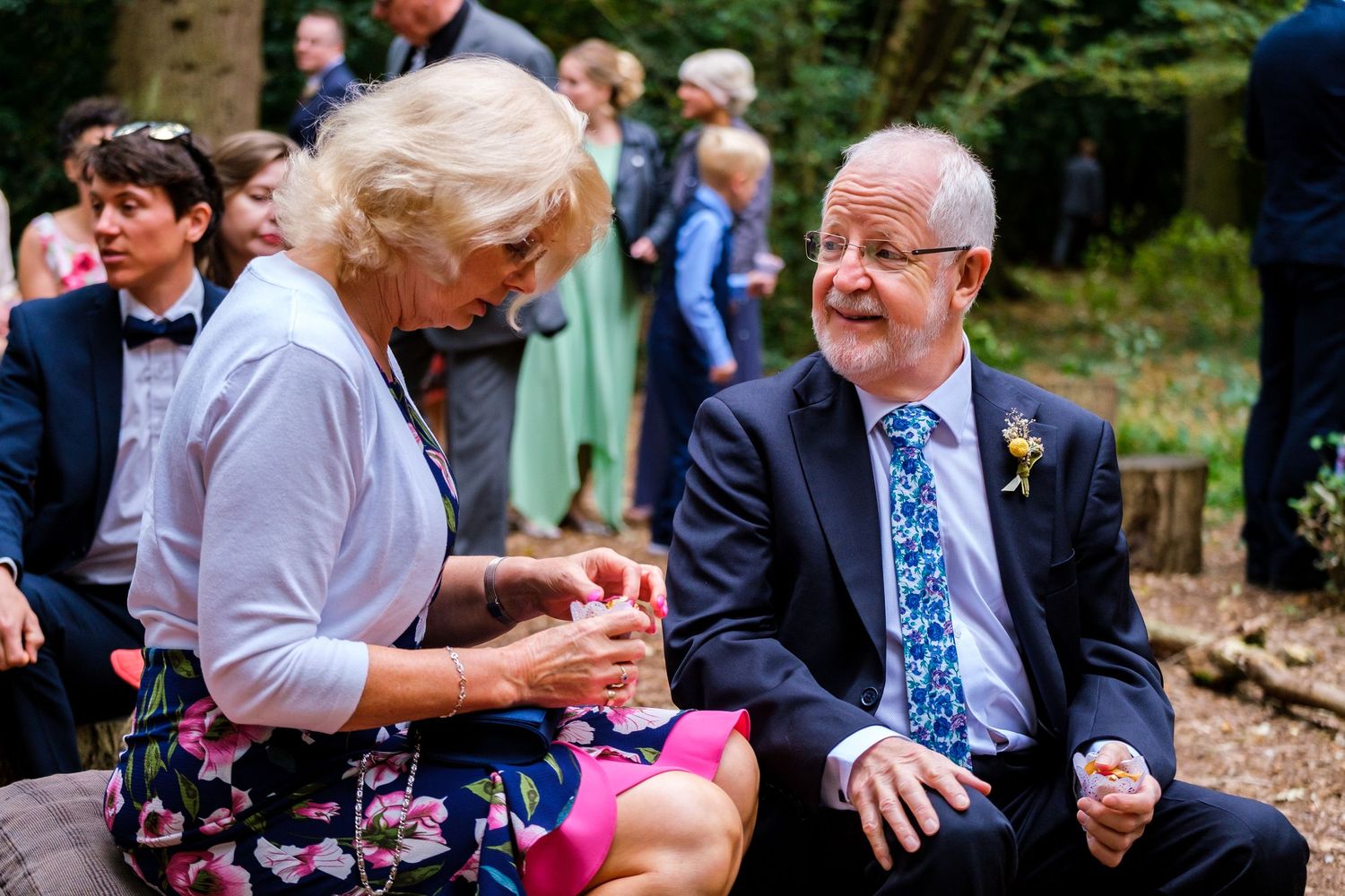 Wedding guests enjoying conversation during an outdoor garden reception.