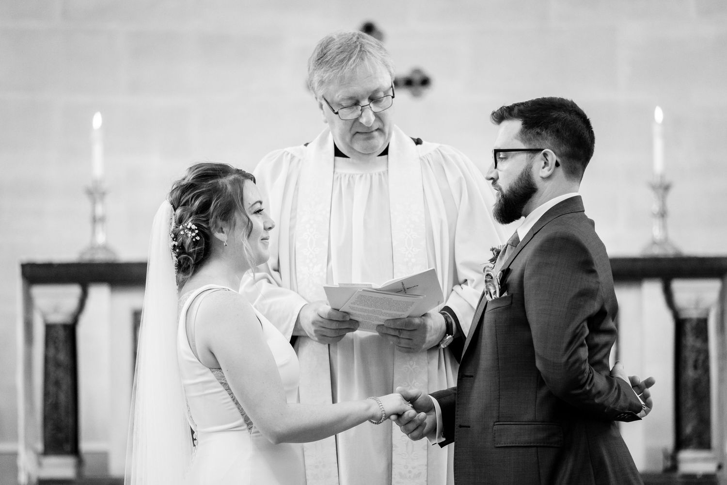 Black and white photo of a wedding ceremony in a traditional church setting.