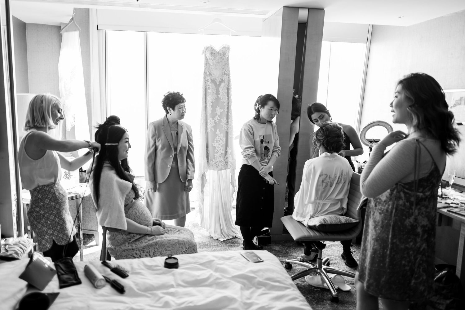 People gather in a bright room for a group activity or workshop with multiple participants visible along a wall.