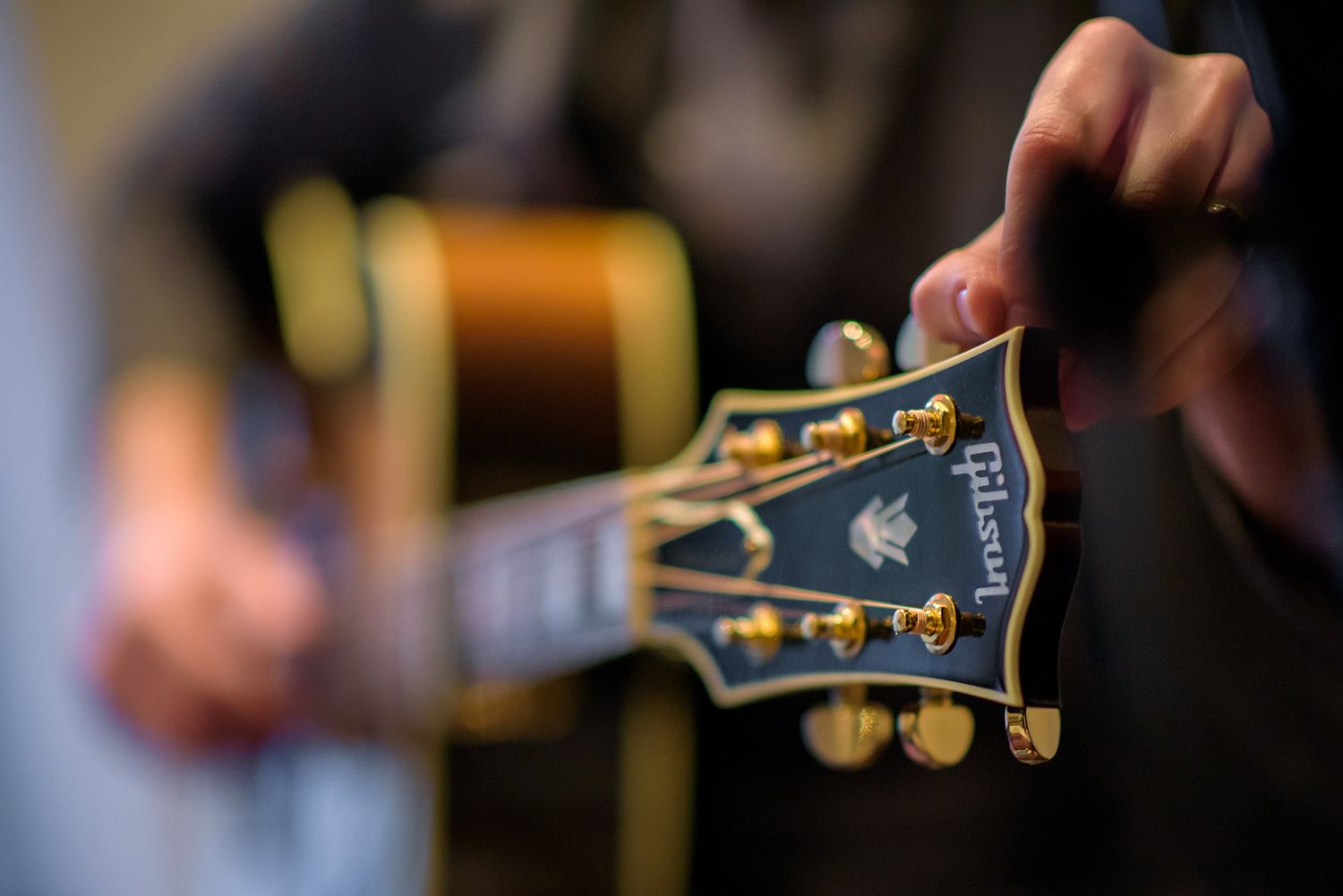 Close-up of guitar headstock and strings at wedding event.
