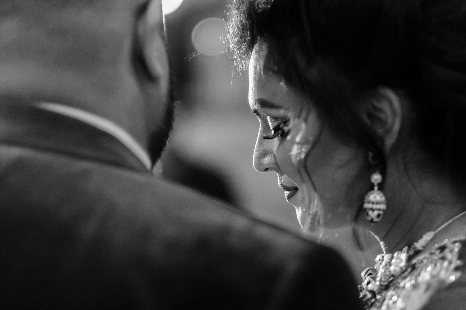 Intimate black and white portrait capturing a tender moment during a wedding celebration.