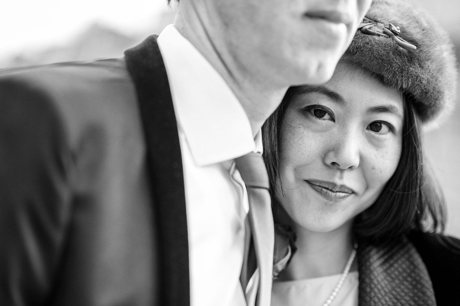 Intimate black and white portrait of a couple in formal attire.